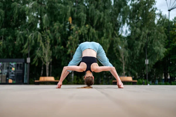 Dívka cvičí jógu a meditaci ve městě. — Stock fotografie