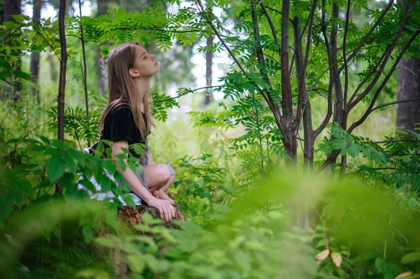 Практика медитации и взаимодействия с природой. Девушка в зеленом лесу — стоковое фото