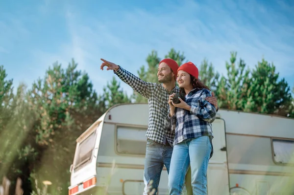 Couple romantique avec une caméra dans la nature près de la remorque à la maison. — Photo