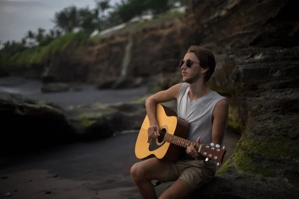 Romantic young man with a guitar on the beach — Stock Photo, Image