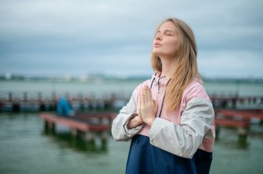 Yoga pratiği ve güneş doğarken meditasyon. Kadının biri rıhtımda pratik yapıyor..