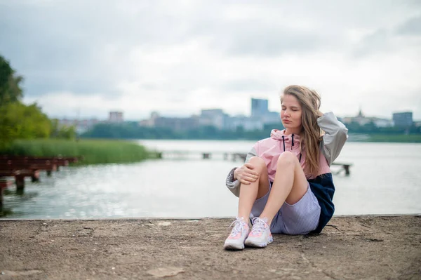 Mädchen sitzt auf Seebrücke beim Morgenspaziergang — Stockfoto