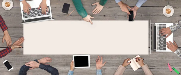 Business Teamwork concept - top view of eight business people. White blank sheet of paper in the middle of the wooden table. — Stock Photo, Image