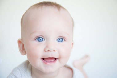 beyaz zemin üzerine mavi gözlü mutlu gülen çocuk