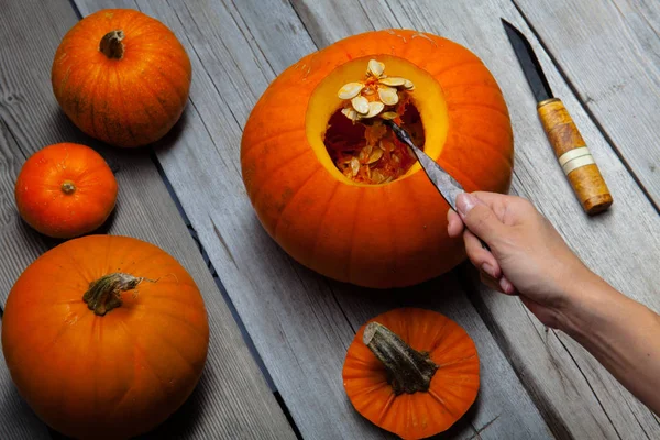 Mädchen bearbeitete Holztisch mit Pampkin für Halloween — Stockfoto