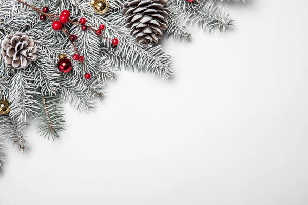 Kerstkaart. Witte achtergrond met sneeuw fir tree en decoratie. Bovenaanzicht met kopie ruimte voor uw tekst — Stockfoto