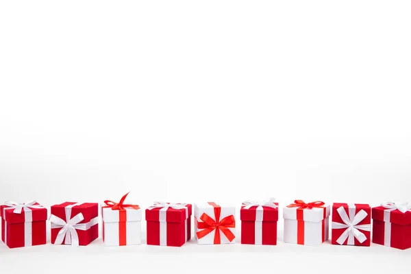 Caixas de presente vermelho e branco de Natal ficar em linha com espaço de cópia. Isolado em branco — Fotografia de Stock