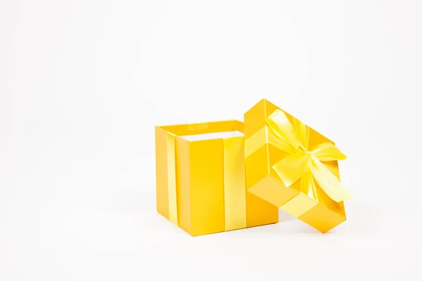 Golden gift box with yellow ribbon isolated on white background — Stock Photo, Image