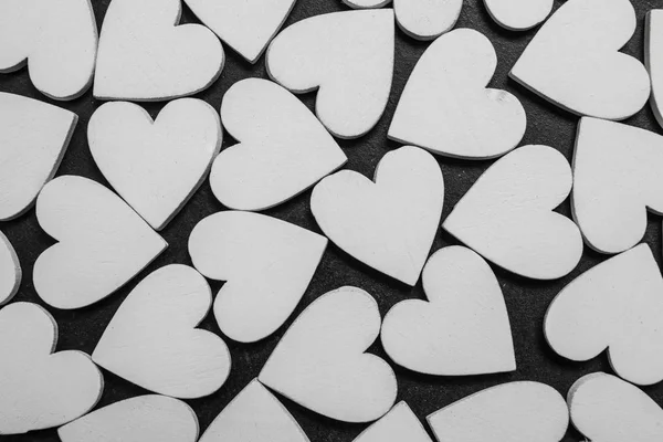 Λευκές ξύλινες καρδιές σε μαύρο φόντο. Μοτίβο του Αγίου Βαλεντίνου. — Φωτογραφία Αρχείου