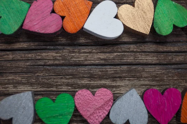 Valentin-napi üdvözlőlap. Egy színes szívek, egy régi fából készült háttér. Hely, a szöveg másolása. — Stock Fotó