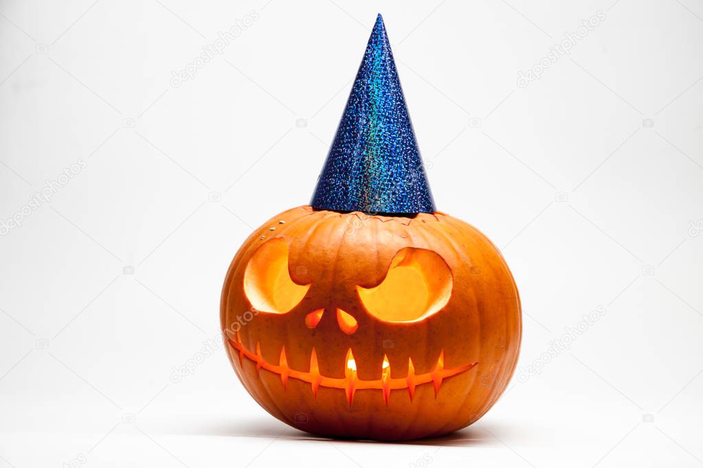 Halloween pumpkin head jack lantern with burning candles with festive hubcap isolated on white background