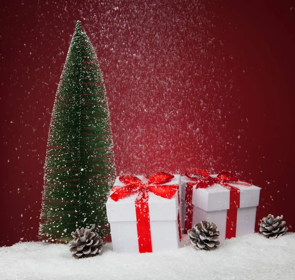 White gift boxes and fir tree on red background. Copy spase for text — ストック写真