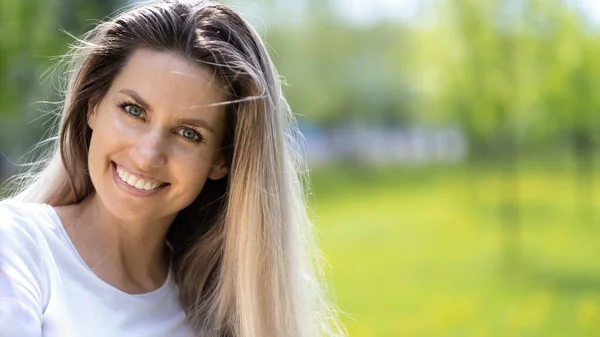 Portrait de jeune belle femme souriante sur herbe verte en été à l'extérieur — Photo