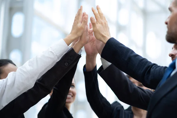 Gelukkige succesvolle multiraciale business team geven een high fives gebaar als ze lachen en juichen hun succes. Rechtenvrije Stockfoto's