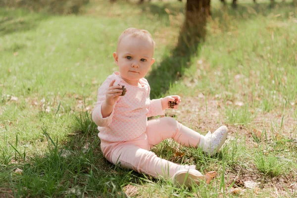 Baby Sits Grass Plays Two Fir Cones She Dressed Pink — Stock Photo, Image