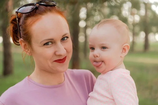 Little Girl Sitting Her Mother Hands Park Shows Her Tongue Stock Picture