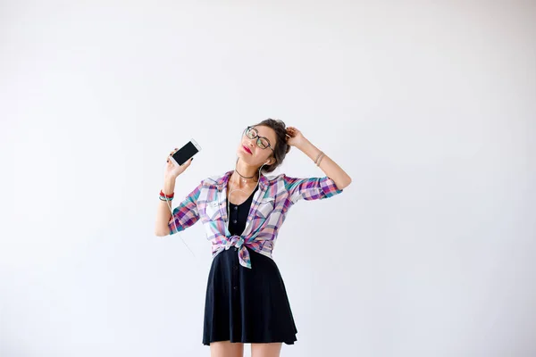 Chica en auriculares y gafas escuchando música y bailando — Foto de Stock