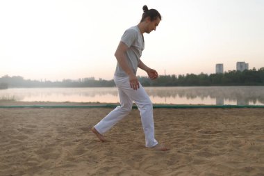 Sahilde hareketleri yapma atletik capoeira sanatçı