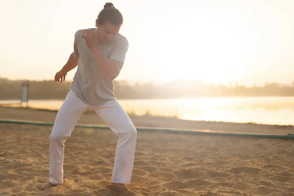 Athletic capoeira performer making movements on the beach — Stock Photo, Image