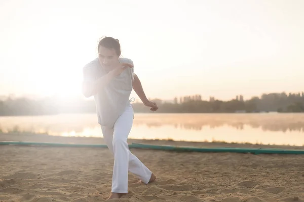 Athletic capoeira performer making movements on the beach — Stock Photo, Image