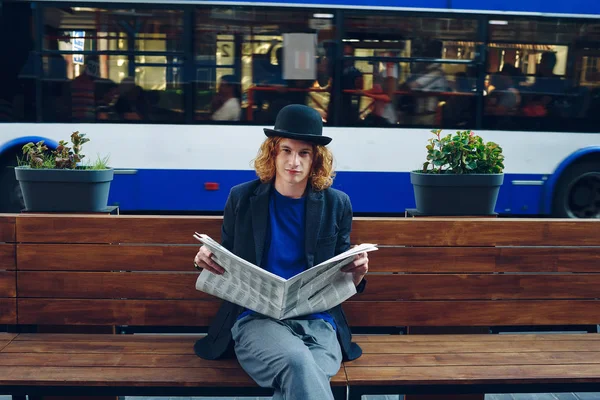 Red haired hipster man sitting on bench with newspaper — Stock Photo, Image