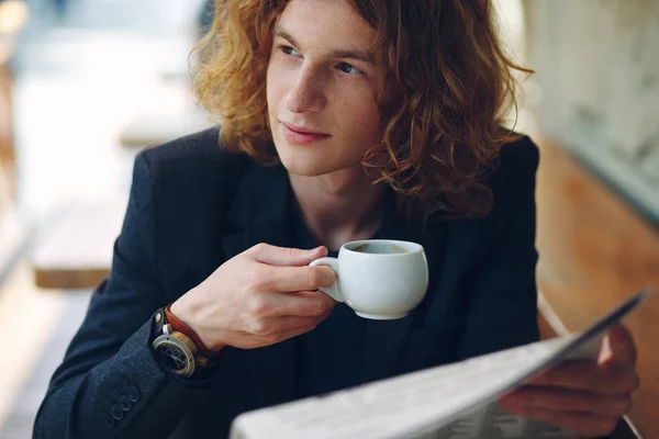 Czerwono-młody przedsiębiorca picia kawy podczas czytania — Zdjęcie stockowe