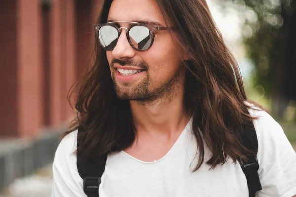 Portret aantrekkelijke man met zonnebril op stedelijke achtergrond smil — Stockfoto