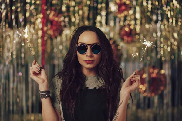 Menina hipster atraente segurando sparklers nas mãos — Fotografia de Stock