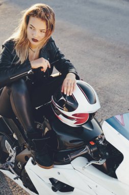 Motosiklet poz üzerinde oturan genç güzel motorcu kadın