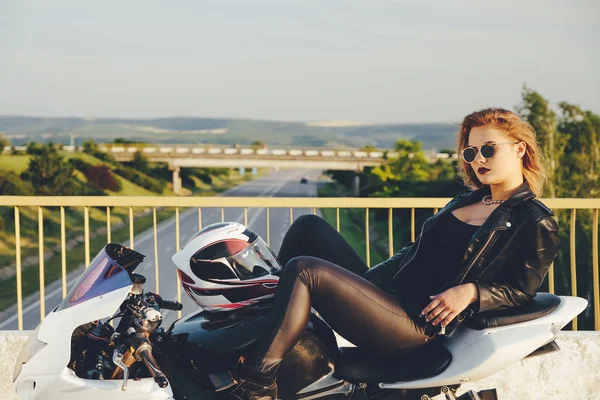 Красивая женщина-байкер лежала на велосипеде расслабляясь — стоковое фото