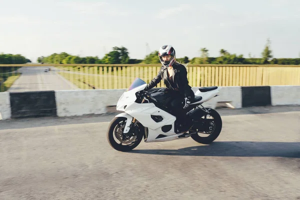 Mulher motociclista dirigindo uma moto em uma estrada — Fotografia de Stock