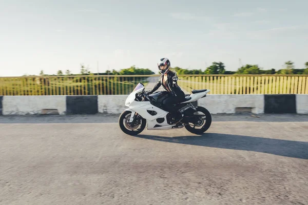 Mujer motociclista conduciendo una moto en una carretera —  Fotos de Stock