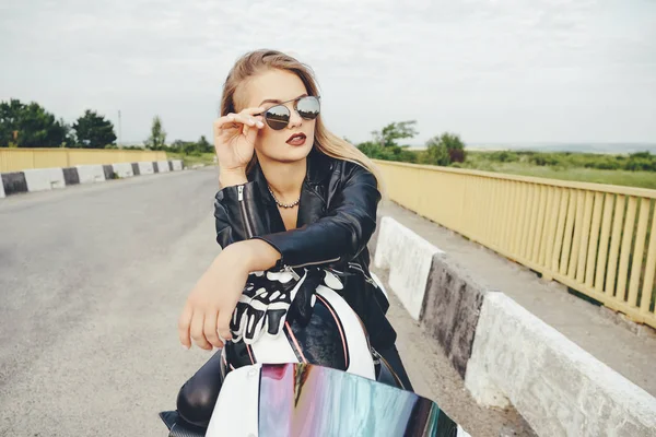 Belle femme posant avec des lunettes de soleil sur une moto — Photo