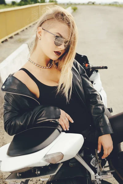 Beautiful woman posing with sunglasses on a motorbike — Stock Photo, Image