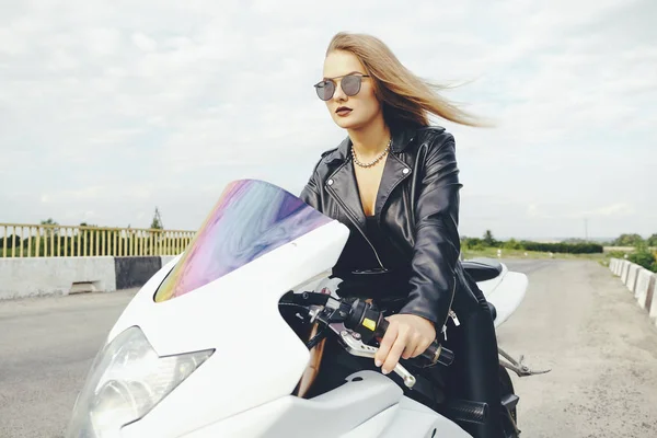 道路でバイクを運転するファッショナブルな女性 — ストック写真