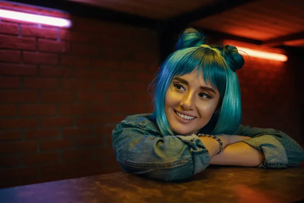 Mädchen im Nachtclub hört jemandem zu, während sie am Tisch sitzt — Stockfoto