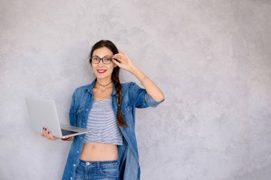 O bir laptop ile ayakta gözlük güzel genç kadın