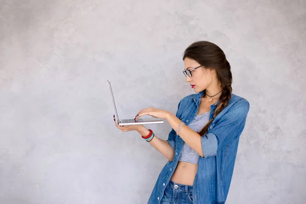 Konzentrierte Frau mit Brille, die konzentriert am Lapto steht — Stockfoto