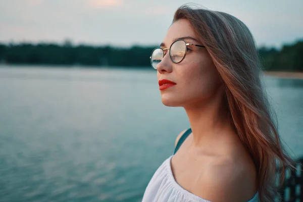 Menina atraente vestindo óculos na vista lago parque — Fotografia de Stock