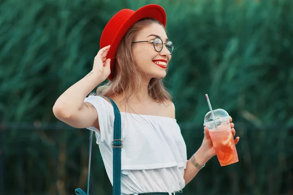 Uma jovem mulher elegante que toma uma bebida refrescante enquanto caminha — Fotografia de Stock