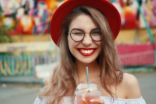 Vrolijke jongedame, houden van een drankje terwijl glimlachen — Stockfoto