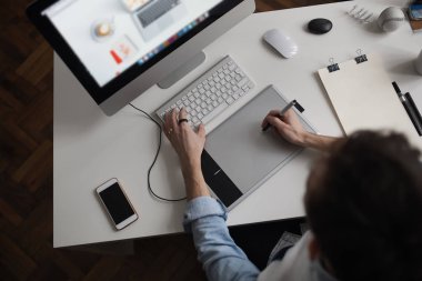 Genç erkek Tasarımcısı grafik tableti kullanarak com ile çalışırken