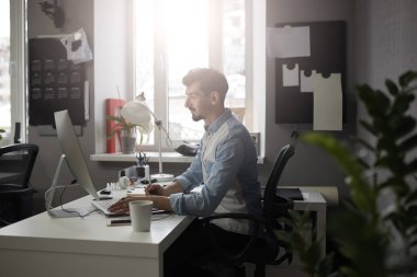 Genç zeki sakallı adam modern loft studio-görevliler çalışma