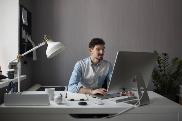 Jovem designer masculino usando gráficos tablet enquanto trabalhava com com — Fotografia de Stock