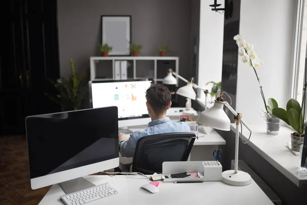 Joven barbudo inteligente que trabaja en el estudio moderno loft-offi — Foto de Stock