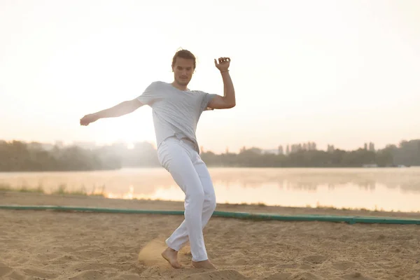 Athletic capoeira performer making movements on the beach — Stock Photo, Image