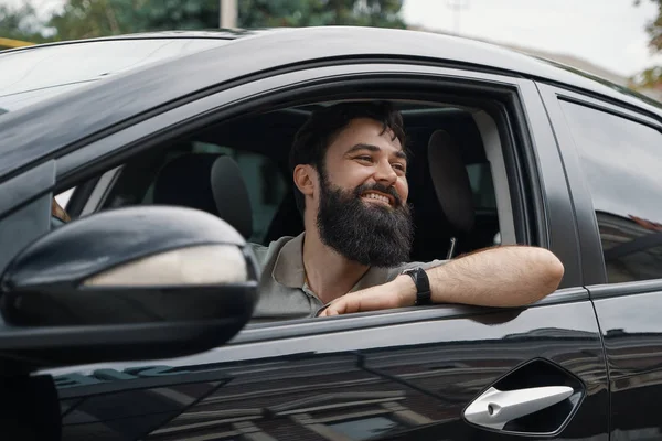 Junger Mann lächelt beim Autofahren — Stockfoto