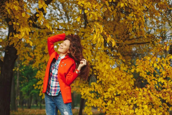 Sonbahar parkta tadını uzun dalgalı saçlı kız. — Stok fotoğraf