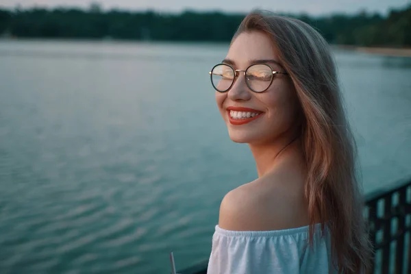 Muchacha atractiva con gafas en vista al lago parque —  Fotos de Stock
