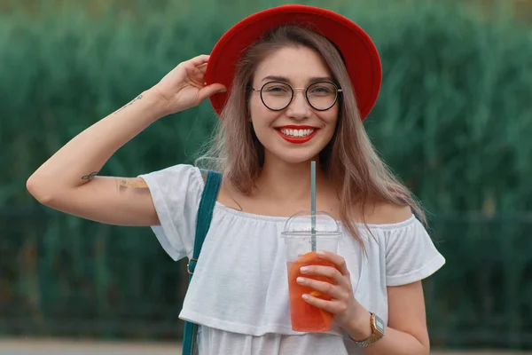 一个年轻时髦的女人在散步时喝着清爽的饮料 — 图库照片